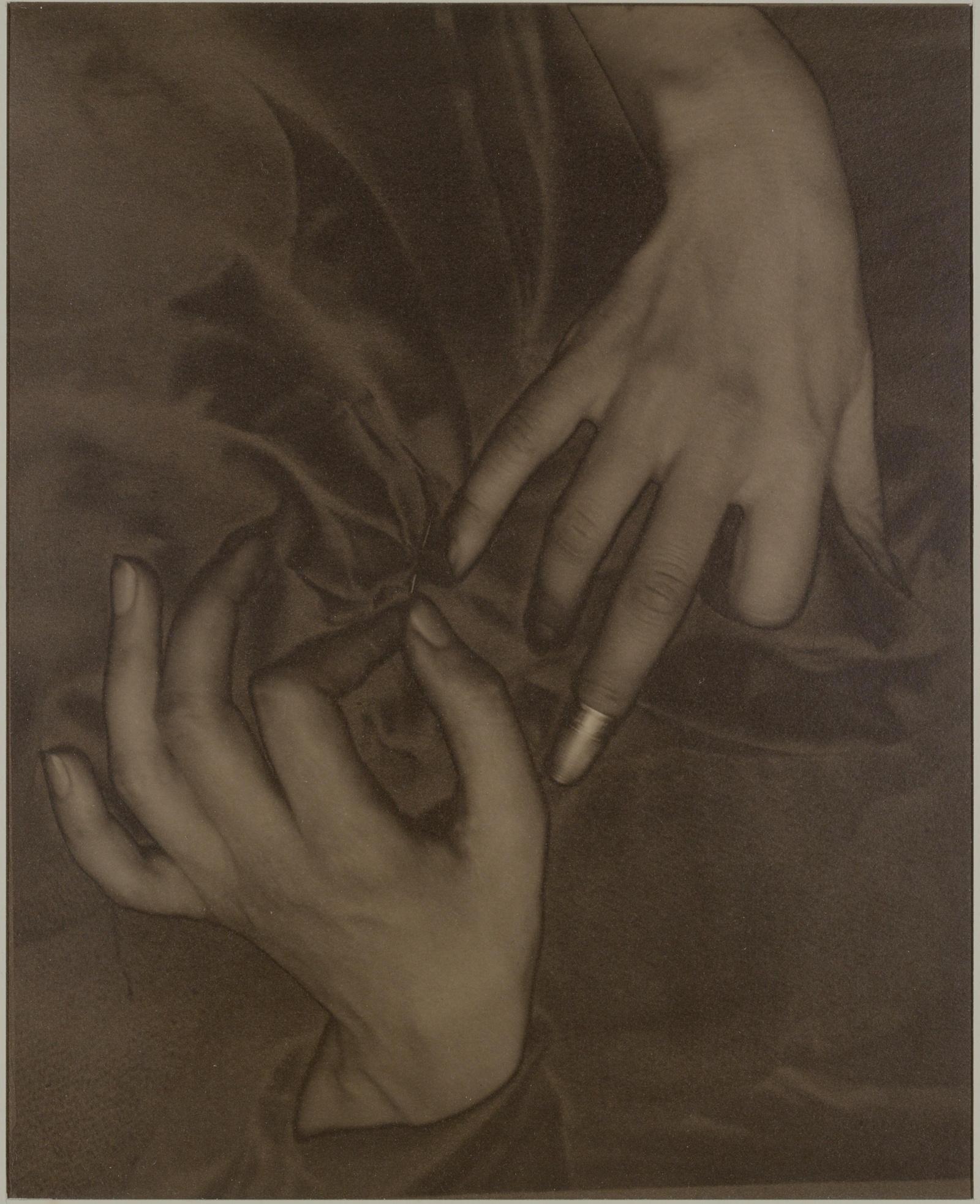 Two hands meeting over cloth, palladium print by Alfred Stieglitz